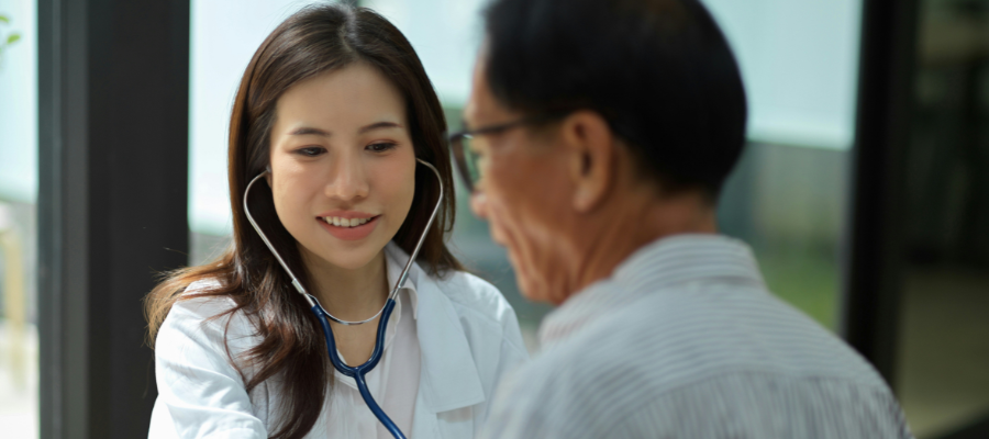 Femme médecin auscultant un patient à Bangkok Hospital, Thaïlande.